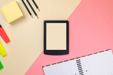 Tablet, okul malzemeleri, defter ve pastel pembe ve bej arka plan renkli işaretleri. Marka kırtasiye maket sahnesi, tasarımınızı yerleştirmek için boş nesneler.