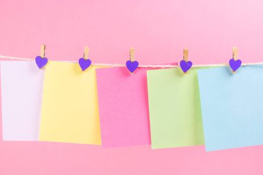 Renkli kağıt kartları pembe arka plan üzerinde izole ip asılı. Metniniz için yer.
