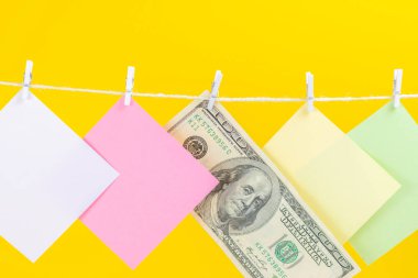 Renkli kağıt kartları ve para sarı arka plan üzerinde izole ip asılı. Metniniz için yer.