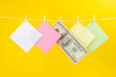 Renkli kağıt kartları ve para sarı arka plan üzerinde izole ip asılı. Metniniz için yer.