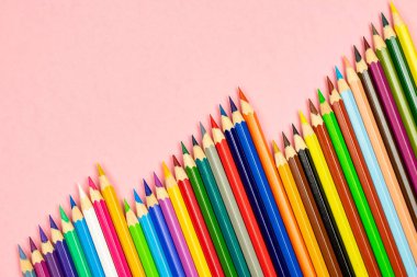 Pembe arka plan üzerinde izole kopya alanı ile renkli kalem. Eğitim çerçevesi kavramı.