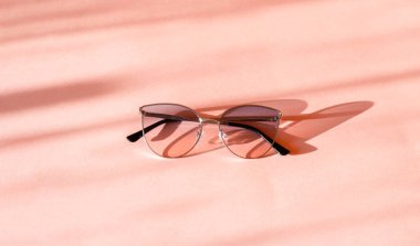 Güneş ışığında trendy pembe kağıt arka plan modern zarif metal çerçeve güneş gözlüğü. Düz yatıyordu. Yaratıcı kontrast yaz görüntü. tatil ve parti kavramı. metin için alan. tropikal yaz tatilleri 