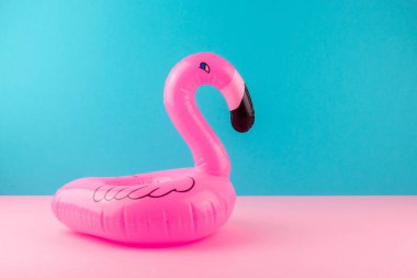 Pastel mavi ve pembe arka plan üzerinde şişme pembe flamingo. Havuz float parti, trendy yaz konsepti. Düz döşeme, kopyalama alanı.