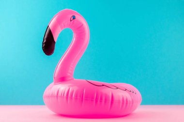 Pastel mavi ve pembe arka plan üzerinde şişme mini flamingo. Havuz float parti, trendy yaz konsepti. Düz döşeme, kopyalama alanı.