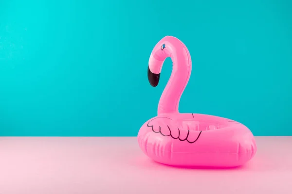 Opblaasbare roze flamingo op pastel blauw en roze achtergrond. Pool float partij, trendy zomer concept. Platte lay, kopieer ruimte. — Stockfoto