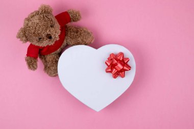Oyuncak ayı, kırmızı yay ile şekillenmiş beyaz kutu kalpler, Sevgililer Günü hediyesi . Noel için hediye, teşekkür veren gün, doğum günü tatili. 