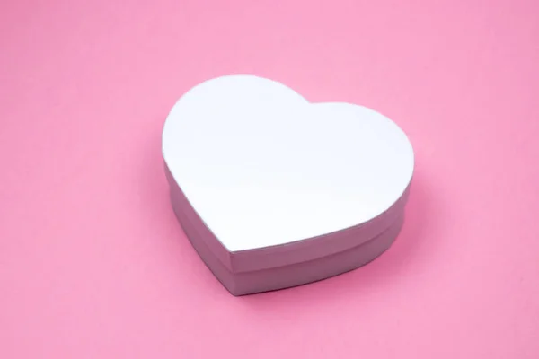 White heart shape gift box for holiday, christmas, thanks giving day, birthday top view isolated on pink background.