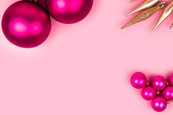 Pink christmas balls, gold Christmas decorations, Gift box on pink background. Holiday and celebration concept for postcard or invitation.