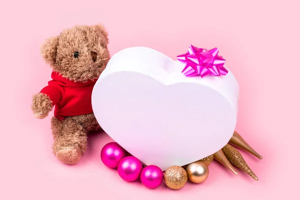 Miś, pudełko z różowymi piłkami i złotymi dekoracjami świątecznymi na wakacje, Boże Narodzenie, dzięki dając dzień lub urodziny, izolowane na różowym tle. — Zdjęcie stockowe