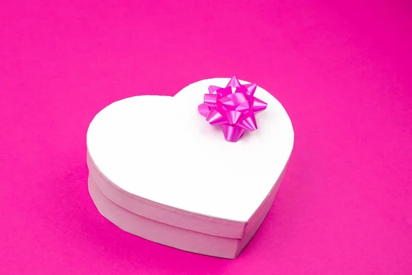 Pudełko na prezent w kształcie serca z różowym kokardą na różowym tle. Makiety. Puste miejsce na napis. Obecny na Boże Narodzenie, dzięki dając dzień, urodziny wakacje. — Zdjęcie stockowe