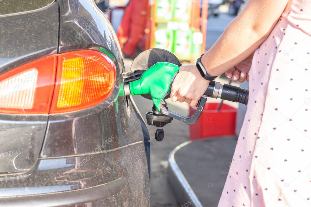 Pretty young woman refuel the car