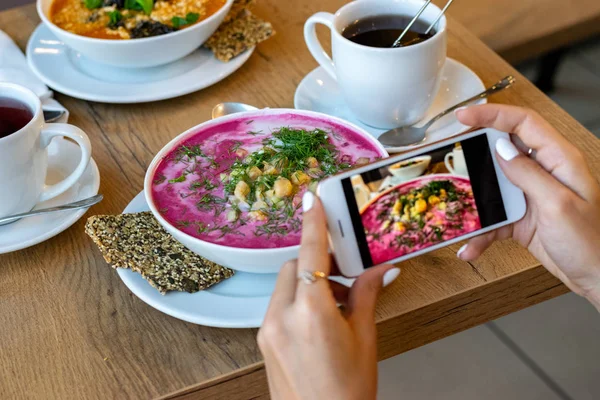 Comida, tecnología, gastronomía y concepto de personas - manos de mujer con smartphone fotografiando sopa en el restaurante —  Fotos de Stock