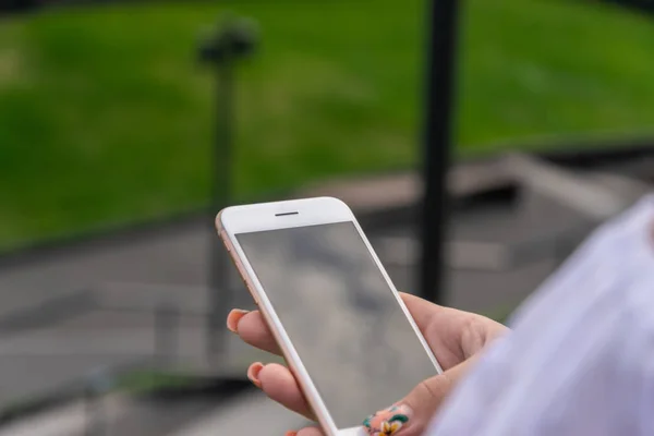 Woman using smartphone in the European city. Hipster girl browsing Internet on a phone, texting and communicating outdoors. — Stock Photo, Image