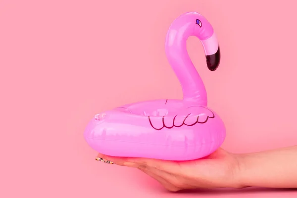 Pembe arka planda izole kadın elinde Mini pembe flamingo. Yaz plaj kompozisyonu. Düz döşeme, kopyalama alanı. — Stok fotoğraf