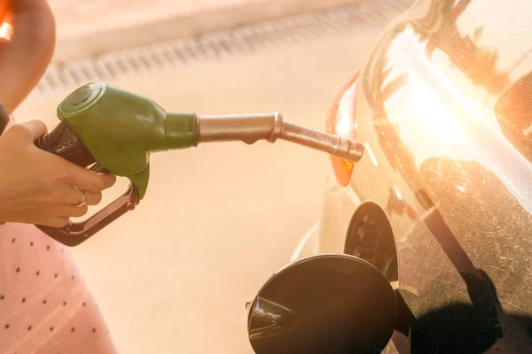 La boquilla de gasolina del coche se llena con gasolina en una gasolinera. Concepto de transporte y propiedad — Foto de Stock