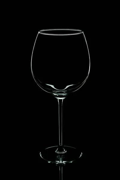 Elegante silueta vacía copa de vino aislada sobre fondo negro. Concepto de consumo de alcohol . — Foto de Stock