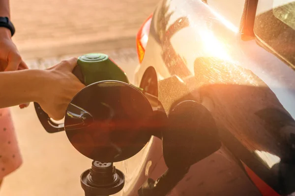 La boquilla de gasolina del coche se llena con gasolina en una gasolinera. Concepto de transporte y propiedad — Foto de Stock