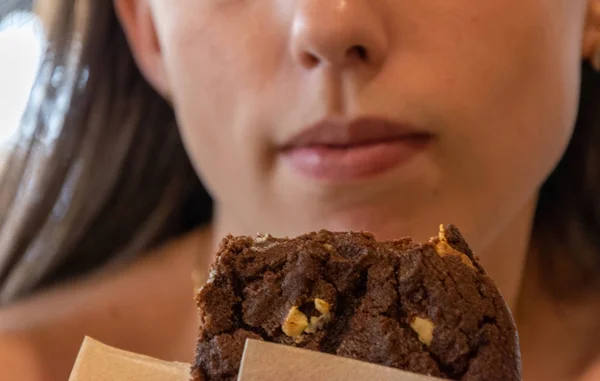 Woman eating American cookies. — Stock Photo, Image