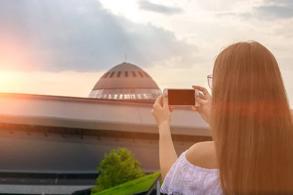 Girl makes a photo on the phone at sunset. Travel concept — Stock Photo, Image