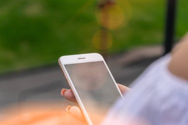 Gün batımında akıllı telefonla mesaj veren kadın