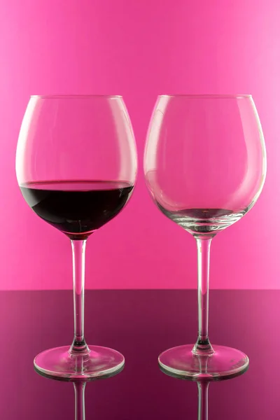 Vinho tinto em copos elegantes isolados sobre fundo rosa. Conceito de vinho . — Fotografia de Stock