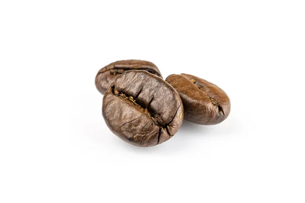 Drei glänzende frisch geröstete Kaffeebohnen isoliert auf weißem Hintergrund. Kaffee Hintergrund oder Textur Konzept. — Stockfoto
