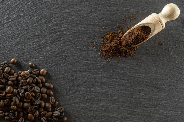 Coffee beans on black caffeine breakfast background. For cup of dark espresso food or drink. Assorted ground and instant brown roasted coffee seeds on stone. Copy space, top view