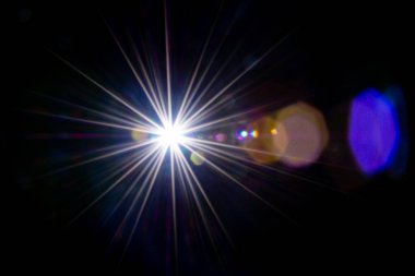 Fişek etkisi. Siyah arka planda güneş ışığı parlaması. Yıldız lekesi ya da güneş objektifte parıldıyor. Fotoğrafların üzerine kaplama ya da ekran filtresi olarak eklemek kolay