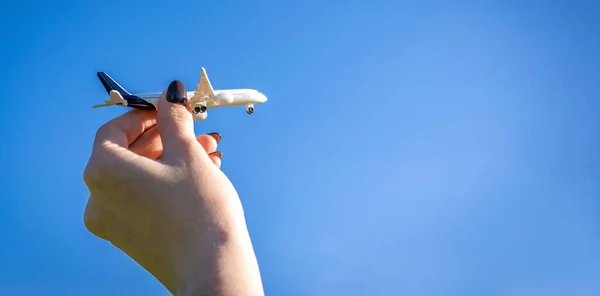 子供の手に高い飛行機の白いおもちゃは 太陽の光の空を飛ぶ 飛行機のフライト 航空機の明るい太陽の下での旅行の背景 空気概念 — ストック写真