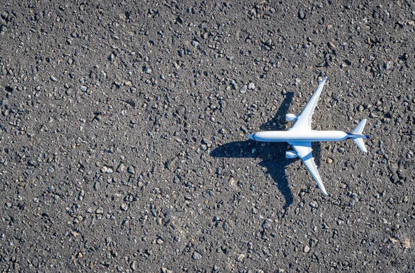 暗いアスファルトの背景に飛行機の白いおもちゃ 明るい飛行機 航空旅行のコンセプトで飛行航空機 コピースペース — ストック写真