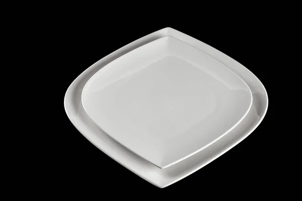 Piring putih kosong untuk makanan yang terisolasi di atas hitam. piring bulat untuk makan malam dengan latar belakang gelap. Restoran konsep minimalistik dapur. — Stok Foto