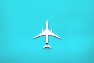 Uçak yolculuğu konsepti. Beyaz oyuncak uçak, parlak mavi uçak. Gökyüzü uçuş arka planı.