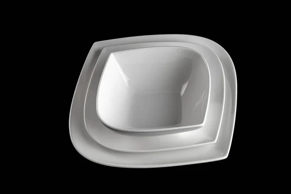 テーブルの上に白い磁器プレート。夕食の背景。黒の背景に丸みを帯びた空のラウンド。レストランキッチンミニマリズムのコンセプト. — ストック写真