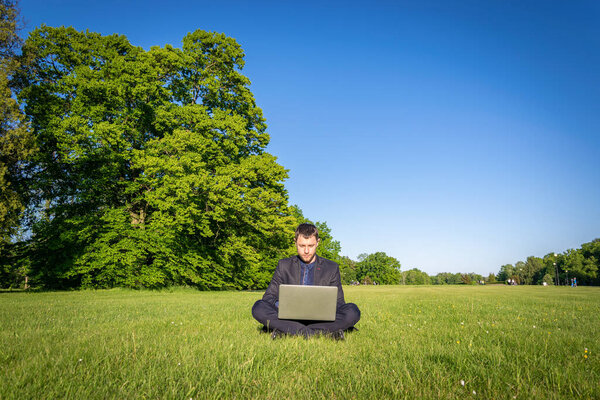 Work laptop outdoor. Student man with computer, tablet in summer nature park. boy does business with online technology outside. Electronic gadgets distance learning concept