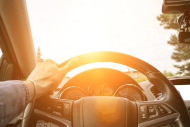 Sür arabayı. Genç ve mutlu bir adam yolda seyahat ediyor. Yaz tatili sürücüsü konsepti. Güneşli bir günde otomatiğin içinde sür