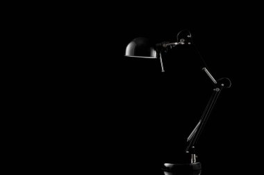 Siyah arka planda izole edilmiş ev eşyaları. Masa başı dekorasyonu için modern masa lambası.