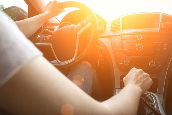 Happy driver inside car at sunset. Young woman have fun ride trip travel on road in summer sunny day. Drive vacation concept