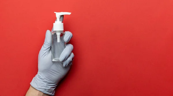 医学的背景赤 ウイルス対策機器の背景にある医療用抗菌サニタイザージェルとラボ用手袋 ポンプボトルの明確な消毒剤 小説コロナウイルス2019 Ncov — ストック写真