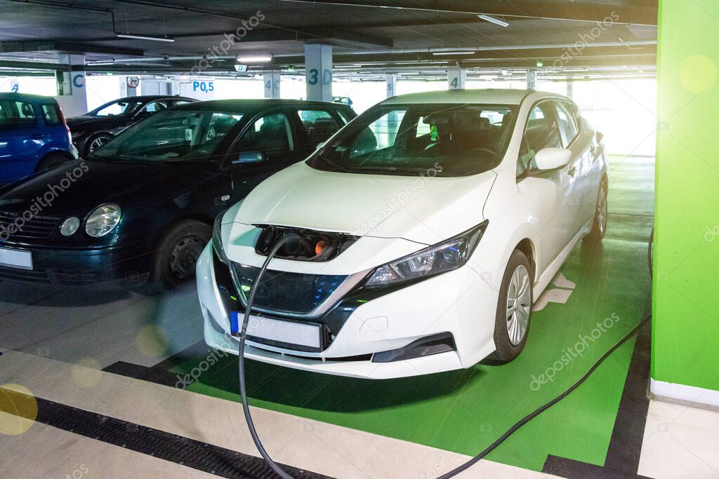 Electric transports. Electric car charge battery on eco energy charger station. Hybrid vehicle - green technology of future. Eco-friendly sustainable energy concept