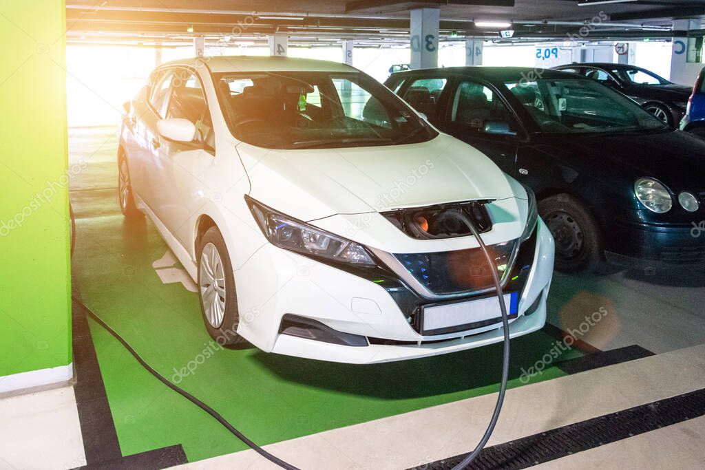 Driving hybrid. Hybrid vehicle - green technology of future. Electric car charge battery on eco energy charger station. Power supply connect