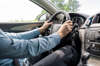 Gün batımında araba yolculuğu. Mutlu genç adam yaz güneşli bir günde içeride araba sürerken iyi eğlenceler. Sürücü gezisi konsepti.