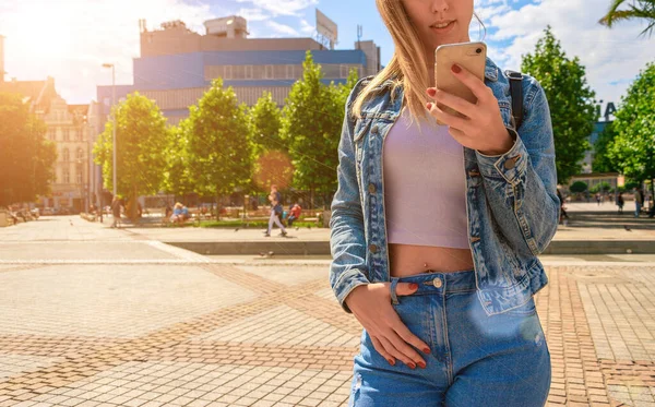 Dívčí léto u jezera. Šťastná mladá dívka s telefonem úsměv, psaní SMS a brát selfie v letním slunci městského města. Hezká samice fotící se na autoportrét. Lidé cestují technologií. — Stock fotografie