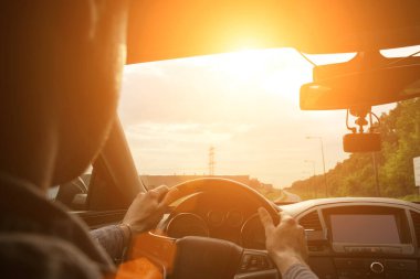 Seyahat arabası. Güneşli bir günde aracın içinde araba süren mutlu genç adam. Yaz tatili konseptinde eğlenceli sürüş.