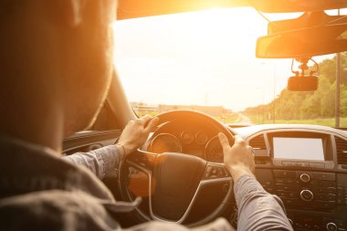 Yolculuk. Mutlu genç adam gün batımında arabada iyi yolculuklar. Şoförle yaz tatili kavramı.