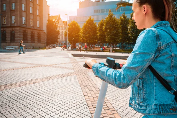 City bike. Electric kick scooter using from woman. Urban lifestyle background. Electric urban transportation concept