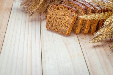 Köy ekmeği. Buğday tohumu kulaklı bir somun taze ekmek ya da ahşap desenli bir bitki. Çavdar ekmeği ve ekmek kırıntılarıyla. Konsept - Evde Yemek Pişirme