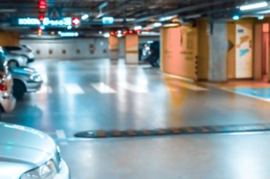 Otomobil bulanıklaştı. Yumuşak odak içinde boş yol asfaltı arkaplanı. Şehir garajındaki otoparkta. Yeraltı otoparkı.