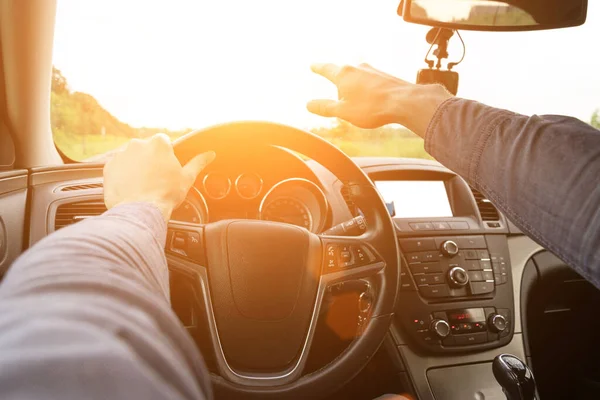 Travel car trip on road at sunset. Happy young man have fun driving inside vehicle in summer sunny day. Driver ride vacation concept