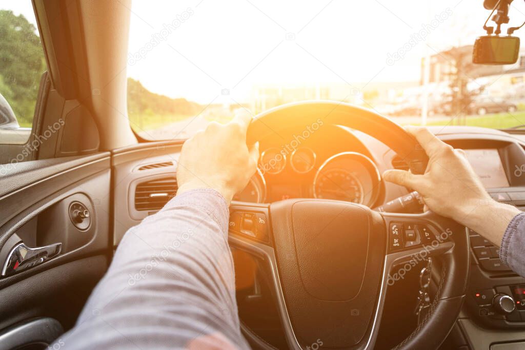 Business man driving car. Travel car trip on road at sunset. Happy young man have fun ride inside vehicle in summer sunny day