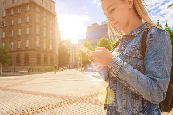 Selfiekvinne. Lykkelig ung jente med telefonsmil, skriver SMS og tar selfie i sommersolskinnsbyen. Pen kvinne som tar et morsomt selvportrettbilde. Forfengelighet, sosialt nettkonsept. – stockfoto